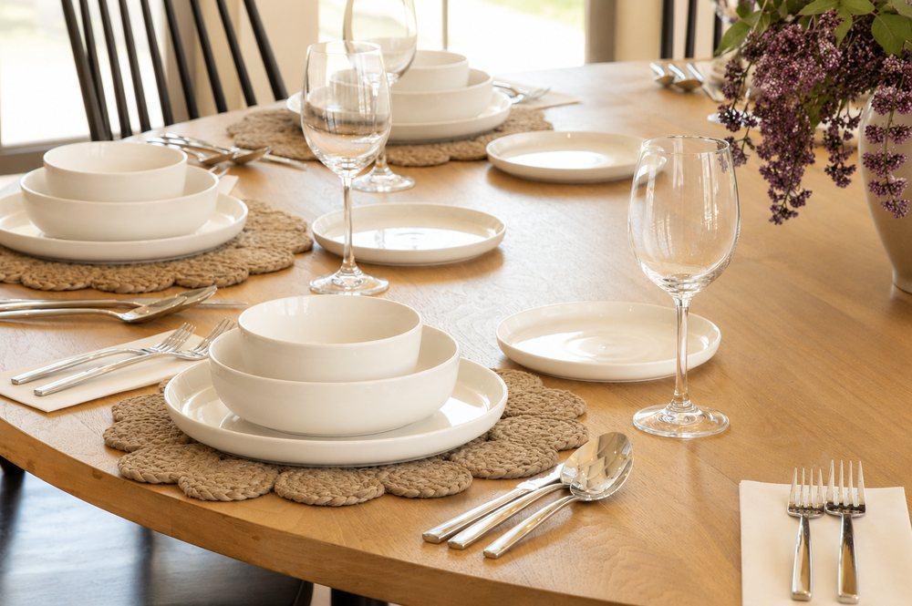 A dining table styled with place settings and wine glasses