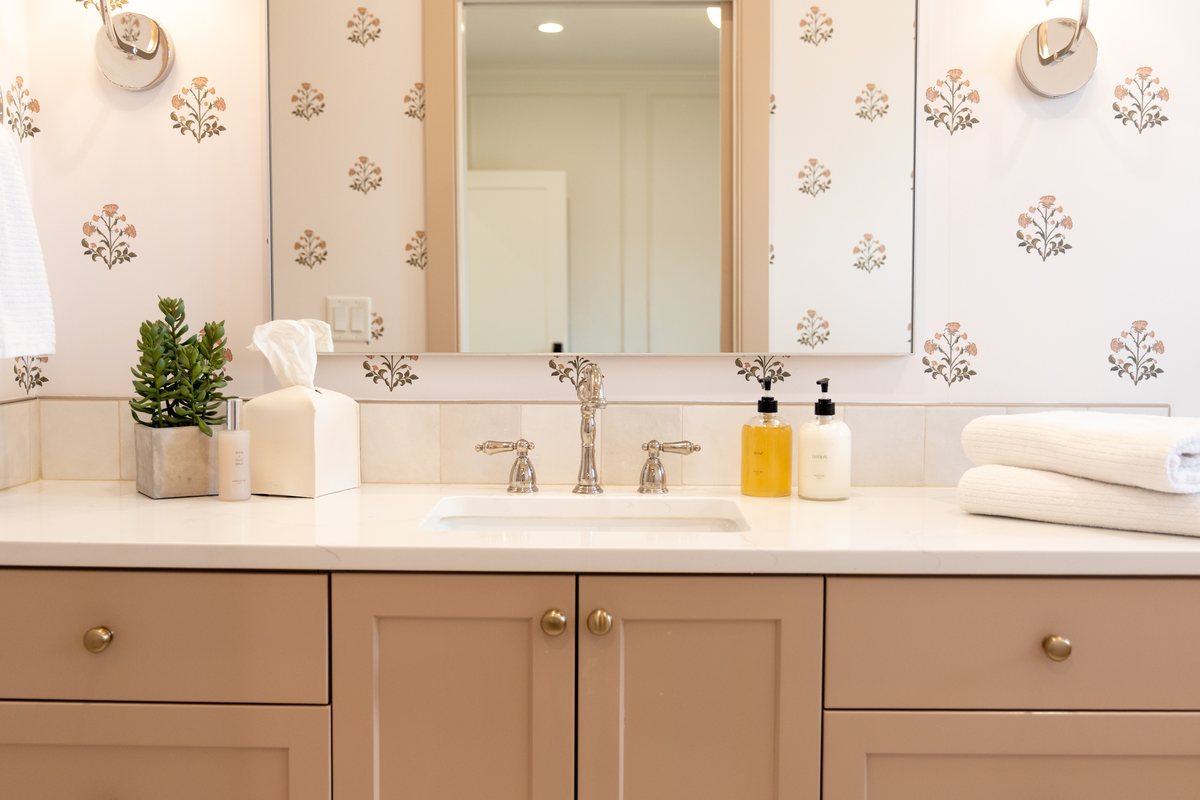 A styled bathroom vanity with soap, lotion, and folded towels
