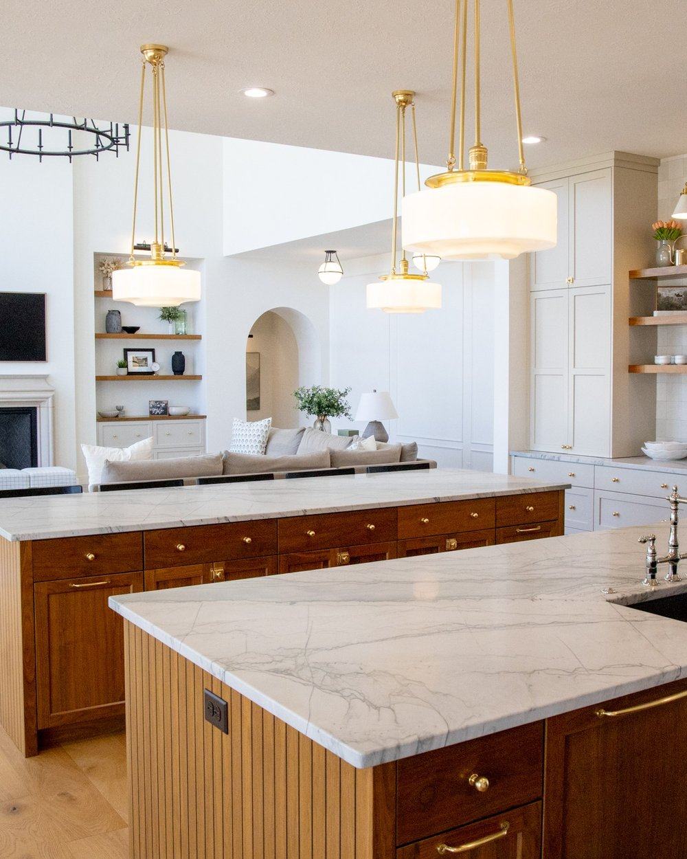 An open-plan kitchen with dual islands and living room beyond